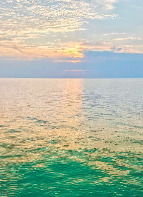 Tengerparti tájkép nyugodt vízfelülettel és horizonttal, amely a belső érzelmi állapotokat idézi meg